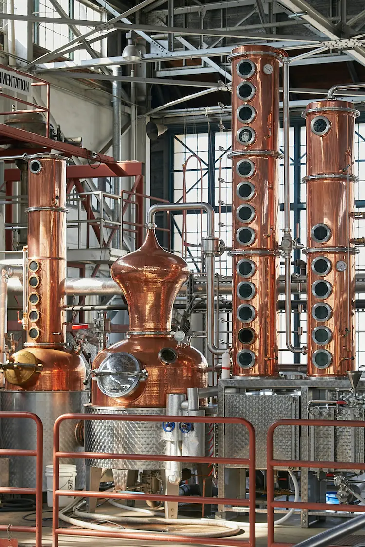 projet-de-distillerie-sur-mesure-brewfactory Colonnes de distillation en cuivre dans une distillerie sur mesure équipée de systèmes industriels modernes