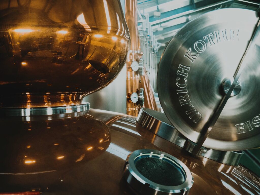 Alambic en cuivre dans un chai en pierre — illustration BrewFactory